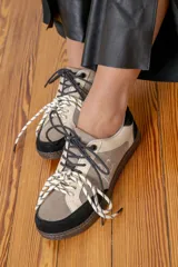 Championes urbanos de diseño patchwork en tonos beige, marrón y negro, con puntera reforzada y cordones bicolores.