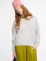 Sweater gris de silueta relajada, con escote en V abierto, puños y ruedo corto. Confeccionado en cachemire extra suave tipo pelo.