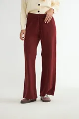 Pantalón de punto de corte recto y holgado, con cintura elástica y cordón ajustable. Presenta costuras verticales decorativas a lo largo de las piernas.