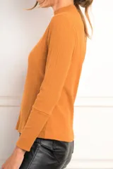 Polera blanca de algodón texturado con cuello alto y mangas largas.