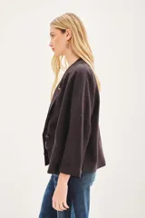 Saco de lino y liocel de corte amplio, con solapa, bolsillos falsos y mangas de largo regular. Incluye un pin decorativo en la solapa.