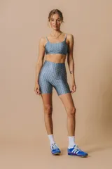 Calza corta tiro alto de cintura ancha con elástico fino en la parte superior. Tejido suave de alta elasticidad con un leve brillo satinado y estampado.