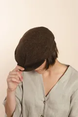 Boina con visera de lana fina uruguaya natural, sin teñir, con diseño de tejido texturizado en tonos beige y marrón.