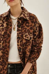 Tapado tipo sobrecamisa con estampado animal print, de corte recto y largo a la cadera. Presenta cuello camisero, cierre frontal con botones y dos bolsillos frontales con solapa.