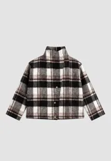 Campera de paño con estampa de tartán escocés en tonos negro, blanco y marrón, de corte boxy, con cuello alto cruzado y cierre frontal de botones metálicos ocultos.