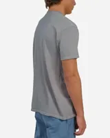 Remera de manga corta color gris con efecto vintage dye, cuello redondo y estampa frontal pequeña en el centro con la inscripción de la marca en tipografía gótica.