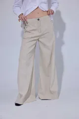 Pantalón de tiro medio y corte ancho, confeccionado en una mezcla de lino y algodón. Presenta costuras verticales frontales, bolsillos laterales y traseros con detalles de remaches.