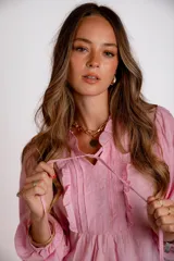 Camisa color celeste con cuello mao, cierre frontal con botones, mangas largas abullonadas con puños elásticos y detalle de volados en el frente.