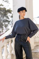 Pantalón negro de cuero sintético, corte recto y tiro alto, con bolsillos laterales y traseros.