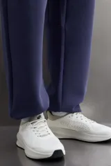 Pantalón jogger relaxed fit Zara Athleticz de tejido técnico compacto elástico con mezcla de algodón. Presenta cintura elástica ajustable con cordón, bolsillos laterales en la cadera, bolsillo trasero con cierre de cremallera, bajo ajustable con elástico y detalle de logo estampado en la pernera.