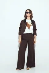 Pantalón de pierna amplia color beige, con silueta relajada y calce cómodo, confeccionado en denim con leve elasticidad. Presenta costuras a contraste.