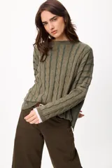 Sweater de punto con diseño de rayas verticales en relieve y textura trenzada, color terracota y beige. Presenta cuello redondo, corte holgado y diseño cropped.