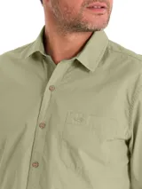 Camisa de manga larga color verde militar, confeccionada en algodón orgánico. Cuenta con cuello camisero, cierre frontal con botones de madera, un bolsillo en el pecho con logo bordado y mangas ajustables.