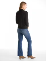 Buzo de punto color beige, con cuello alto y manga larga. Presenta un diseño de tejido liso con detalle de canalé en los hombros y puños.