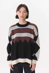 Buzo de tejido de punto con diseño geométrico y combinación de colores en contraste. Presenta cuello redondo, mangas largas y corte oversized.