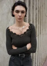 Remera de manga larga gris oscuro con cuello en V adornado con detalles de puntilla negra.