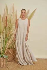 Vestido largo color beige claro, sin mangas y con cuello redondo.