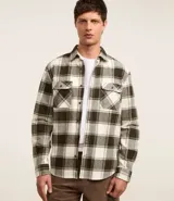 Camisa de franela para hombre con estampado de cuadros en tonos blanco, gris y negro. Tiene cuello camisero, mangas largas, cierre con botones, dos bolsillos delanteros con solapa y corte comfort.