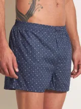 Bóxer de algodón blanco con estampado de flores pequeñas color celeste, con cintura elástica y logo de la marca en el centro.