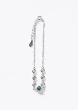 Pulsera de plata 925 con cadena eslabonada, decorada con zirconias circulares y un dije central en forma de corazón con una zirconia verde rodeada de pequeñas zirconias blancas. Incluye cadena de extensión.