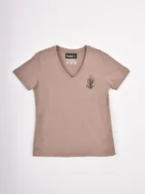 Remera de cuello en V color beige, de corte regular y manga corta, con un pequeño bordado floral en el pecho.