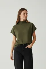 Chaleco de punto de manga corta con cuello alto, confeccionado en tejido de viscosa con textura sutil.