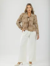 Camisa color crema con bordados florales, de corte recto y mangas largas.