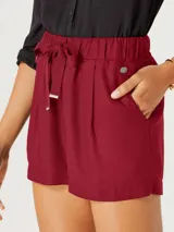 Short femenino color fucsia, de tiro alto con cintura elástica fruncida y lazo ajustable a tono. Presenta pliegues frontales y bolsillos laterales.