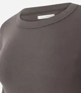 Blusa de manga larga con cuello redondo, confeccionada en tejido rib acanalado. Presenta un diseño ajustado al cuerpo y textura vertical en relieve.