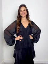 Vestido largo de seda italiana color chocolate, con escote en V, mangas largas abullonadas y diseño de múltiples volados horizontales que aportan volumen y movimiento.