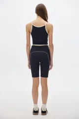 Calza biker corta de tiro alto color negro con detalles deportivos en color crema.