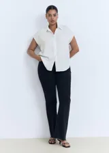 Camisa sin mangas de lyocell, color blanco, con cuello camisero y cierre frontal de botones.
