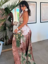 Vestido largo sin mangas con escote en V pronunciado, de corte amplio y fluido, con estampado abstracto en tonos rosados, marrones y blancos, y un cordón trenzado ajustable en la cintura.