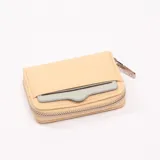 Monedero beige con cierre de cremallera y tarjetero externo.