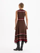Vestido midi de punto sin mangas con diseño plisado. Presenta un corte evasé con rayas horizontales en tonos rojo, rosa y negro en el cuello, la cintura y el ruedo, el cual cuenta con terminaciones irregulares y detalles de transparencia.