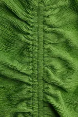 Vestido largo sin mangas de color verde, confeccionado en punto con efecto arrugado. Presenta escote en V con fruncido central en la parte delantera, costuras drapeadas y falda con vuelo con corte fruncido bajo las caderas.