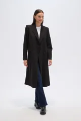 Tapado largo cruzado de poliéster, color negro con finas rayas verticales blancas (pinstripe). Presenta solapas anchas de muesca y doble botonadura.