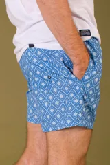 Short de baño azul marino con estampado de flores celestes, cintura elástica regulable con cordón y bolsillos laterales.