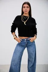 Sweater negro de tejido de punto con diseño de trenzas verticales, cuello redondo y corte cropped.