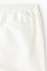 Short de corte regular fit en mezcla de algodón y lino color blanco, con cintura elástica, cordón ajustable, botón frontal, bolsillos laterales y bolsillos traseros ojalados.