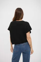 Chaleco de punto negro con cuello en V y mangas cortas, confeccionado en un tejido texturizado con sutil brillo.