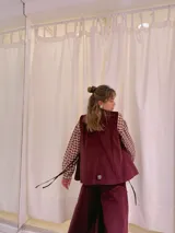 Chaleco largo de terciopelo color bordó, con corte recto y sin cierre.