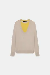 Jersey de punto con lana, de diseño combinado con cuello en V profundo en color beige y detalle interior en color amarillo. Presenta mangas largas con puños ajustados.