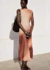 Vestido midi de gasa con diseño degradado en tonos tierra, cuello redondo y tirantes anchos. Presenta un corte fluido, cierre de botón en la parte posterior y forro interior.