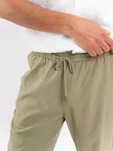 Pantalón de corte relajado, color verde militar, con cintura elástica y cordón ajustable.