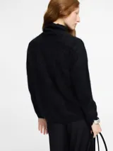 Sweater negro de tejido fino con textura peluche y cuello alto estilo tortuga. Modelo de corte holgado.