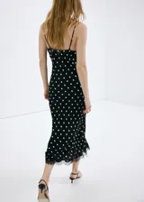 Vestido midi negro con estampado de lunares blancos, escote en pico con detalle de encaje, tirantes y diseño fluido de corte recto.