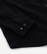 Camisa de manga larga confeccionada en sarga de algodón color verde menta, con cuello inglés y cierre frontal de botones negros. Presenta dos bolsillos de parche con solapa en el pecho y puños con botones.