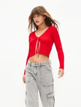 Saco rojo de tejido de punto con escote en V y lazo de ajuste en el frente.