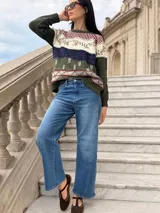 Sweater de tejido de punto artesanal en color verde oliva, con diseño de guardas geométricas y motivos botánicos bordados en tonos blanco, azul y rojo. Presenta cuello redondo, mangas largas y terminaciones en tejido acanalado.